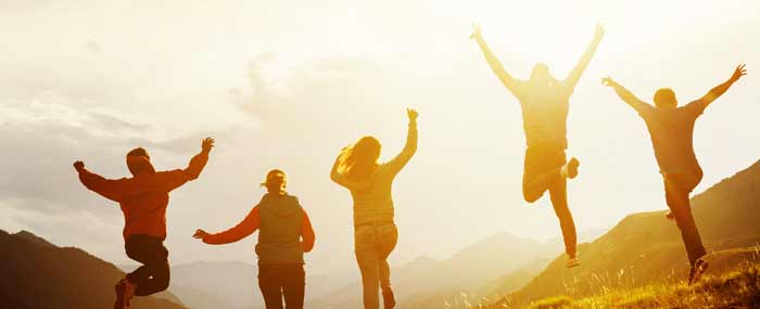 friends jumping into the sunset