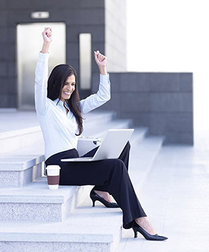 successful woman on staircase with laptop