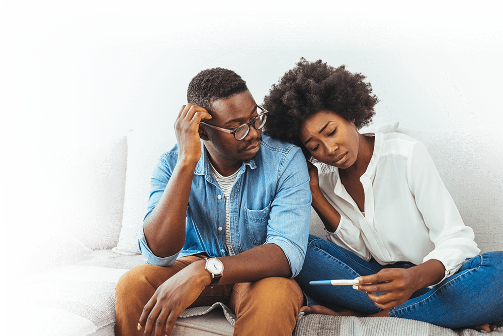 Sad couple holding pregnancy test with negative result