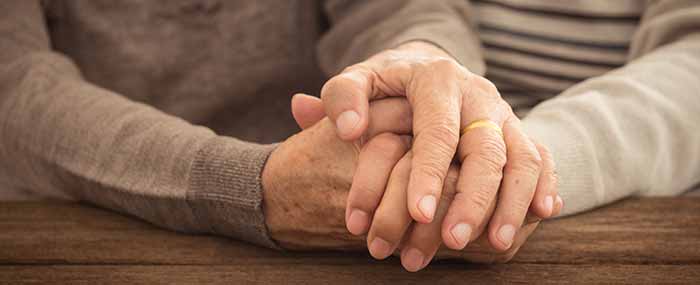 married elderly couple holding hands